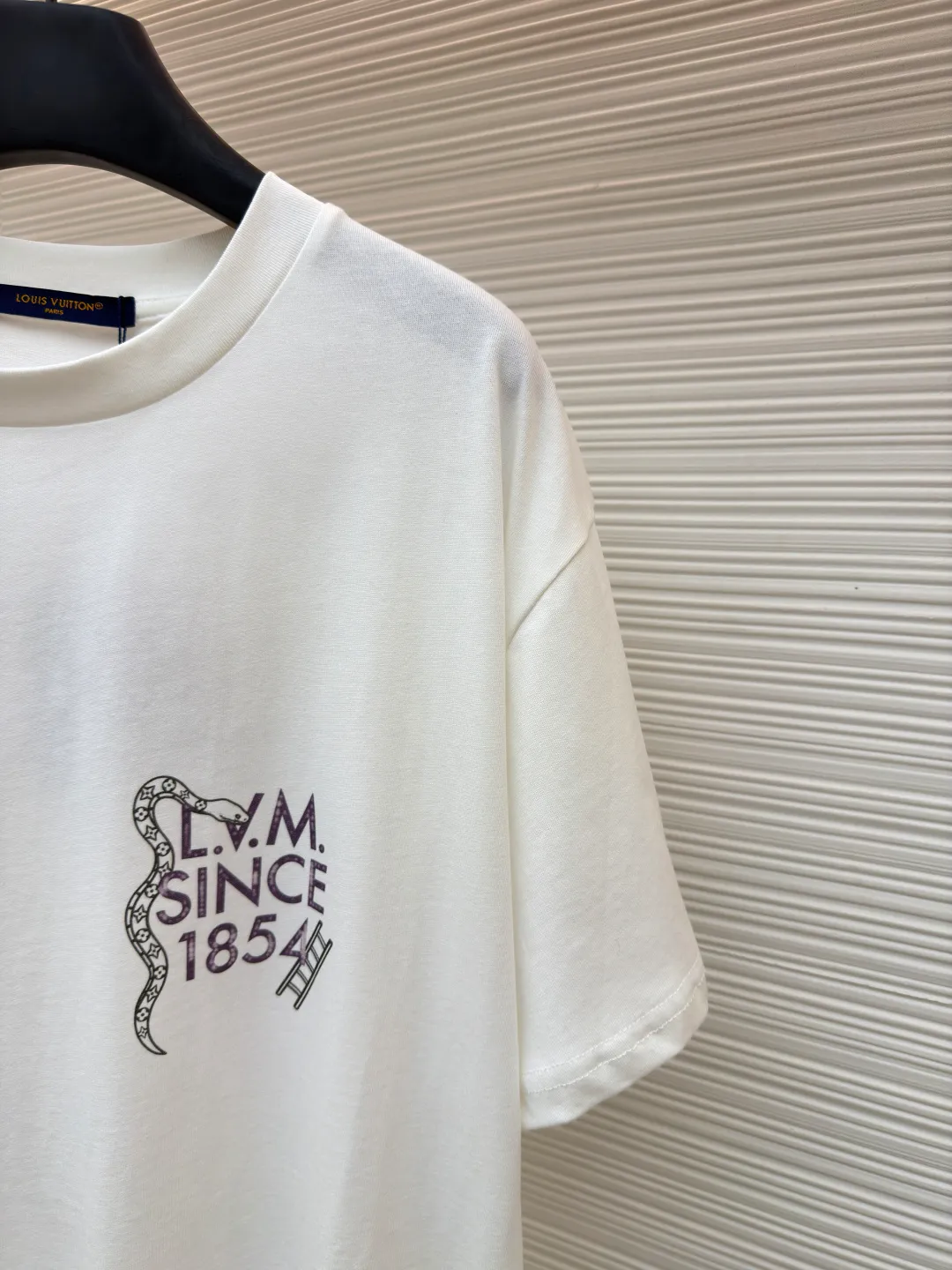 LOUIS VUITTON round neck printed short-sleeved T-shirt ●Original version: Purchased and developed at 7450 ●Item number: 1682214-A10 ●Fabric: cotton fabric ●Technology: Printing ●Color: white ●Version: fitted version ●Weight: about 260 grams ●Size: S-M-L-XL ●Description: This printed short-sleeved T-shirt is made using high-end garment technology. The fabric is made of 230g heavyweight double-strand combed cotton. It is treated with an enzyme washing process to make the cotton soft to the touch and not easy to pill or deform, while retaining the breathability and skin-friendly properties of cotton. The back theme printing uses a composite process of digital direct inkjet printing and screen printing. First, digital direct inkjet printing is used to restore the color gradation and delicate texture of the pattern, and then screen printing is used to outline the outline of the pattern, which increases the color firmness of the printing by 30% and does not fade or crack after repeated washing. The neckline is hemmed with two stitches and is paired with high-elastic rib fabric, which is resistant to pulling and does not deform after long-term wear. The side seams and shoulder seams of the body are sewn with embedded clip technology, and the stitching is fine and smooth. The overall shape is created through three-dimensional tailoring to create a loose shoulder drop effect, taking into account both wearing comfort and stiffness. The overall wiring is straight and delicate, the fabric is comfortable and soft, and the color is consistent without color difference. It can be matched with the same style to create a fashionable look and control various occasions. Customized accessories, complete with three standards, same style for men and women!